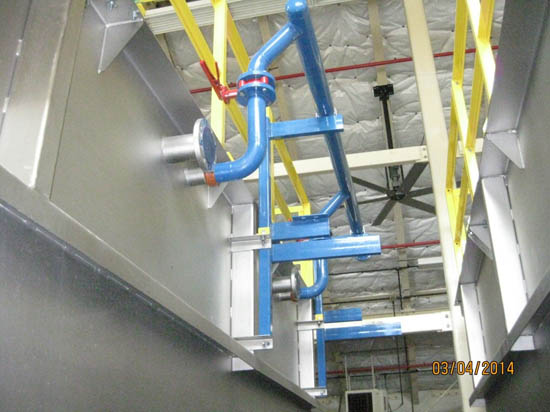 Blue piping and yellow railing in an industrial setting, ceiling fan visible.