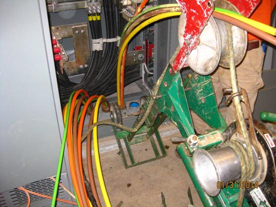 Electrical cables in a panel, cable rollers, and a winch machine for cable installation.