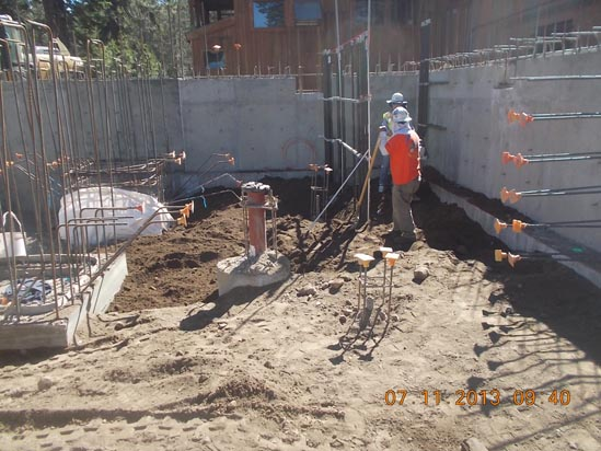 Construction site with workers, rebar, and concrete walls.