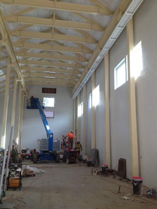 An indoor construction site with a lift, workers, and equipment.