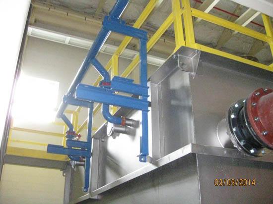 Industrial pipes and metal structures with blue and yellow components inside a building.