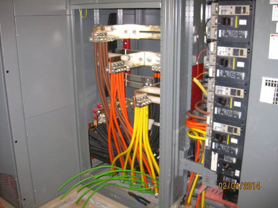 An electrical panel with various colored wires and circuit breakers connected inside.