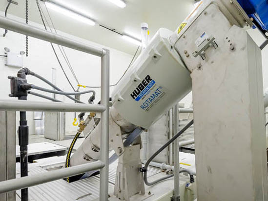 Industrial equipment labeled "Huber Rotamat" in a factory setting with pipes and metal structures.