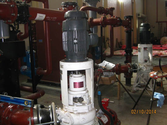 Industrial equipment with pumps and piping in a mechanical room setting.