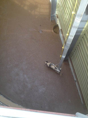 The image shows the interior of a grain silo with a sweep auger positioned against the grain surface.
