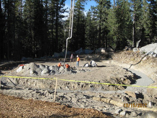 Construction site with workers and machinery in a forested area, dated 10/15/2012.