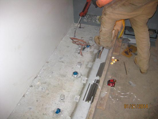 A person working on the floor with electrical wires and tools, likely doing electrical installation or repair work.