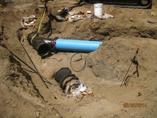 Construction site with pipes, tools, and sand.