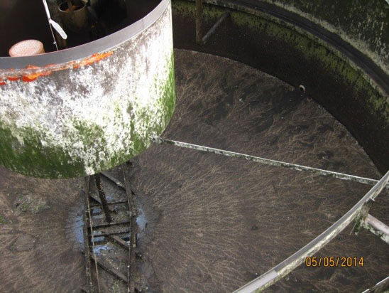 A large, rusted and mossy industrial tank with a central structure, taken on 05/05/2014.