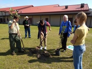 May contain: person, plant, planting, grass, tree, clothing, hat, backyard, nature, outdoors, and yard