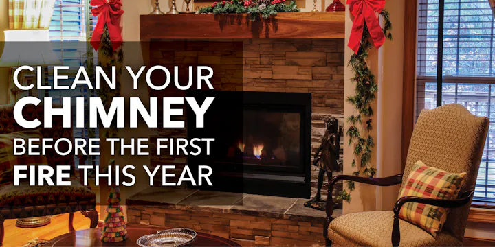 A cozy living room scene with a fireplace, urging to clean the chimney before the first fire of the year.