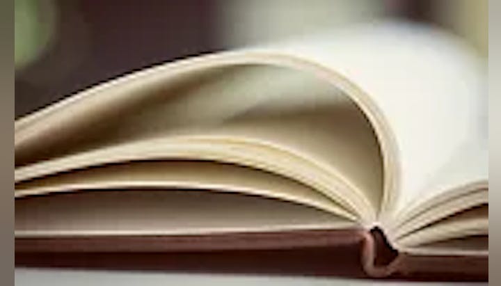 An open book with pages fanned out on a desk.