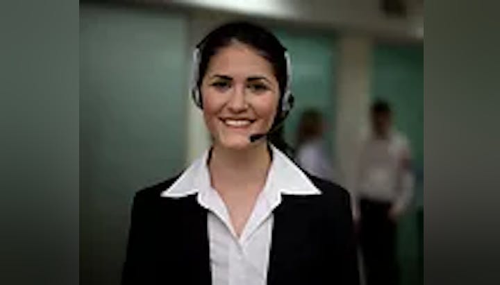 A smiling woman wearing a headset and a business suit.