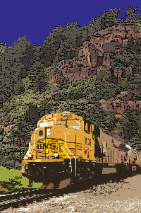 A yellow freight train passing through a rocky landscape with trees under a blue sky.