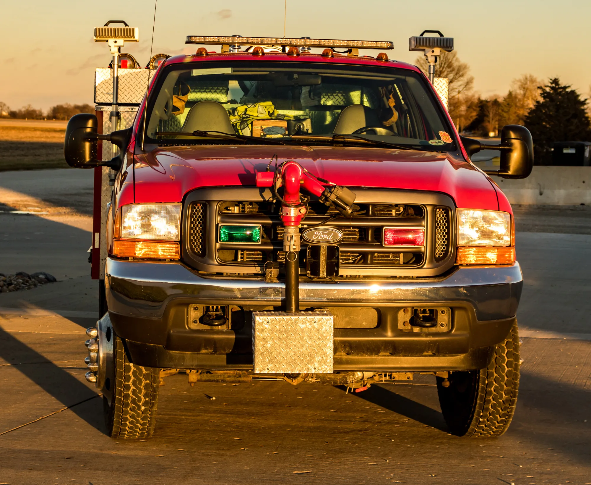 A red fire department truck with lights and equipment, parked on a concrete surface.