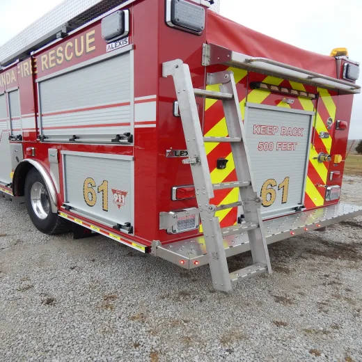 A red fire truck with the number 61, "Keep Back 500 Feet" warning, ladder, and gravel ground.