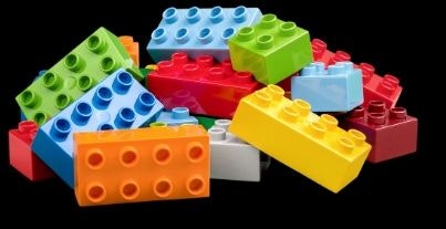 A pile of colorful building blocks on a black background.