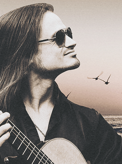 A man with long hair and sunglasses is playing a guitar against a beach sunset backdrop with flying birds.
