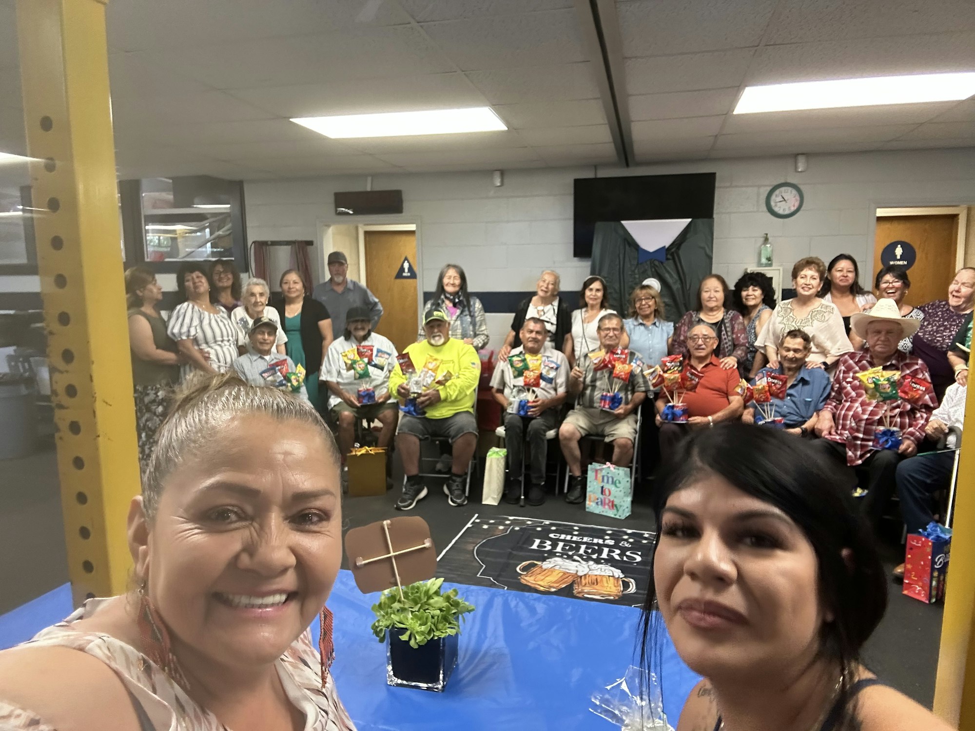 Group of people posing with snacks and gifts in a room.