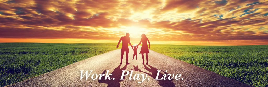 A silhouette of a family walking into the sunset on a road, with the text "Work. Play. Live."