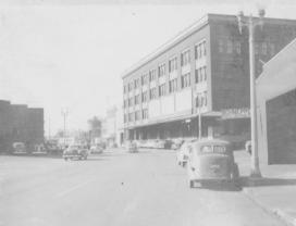 Vintage street scene with old cars and buildings.