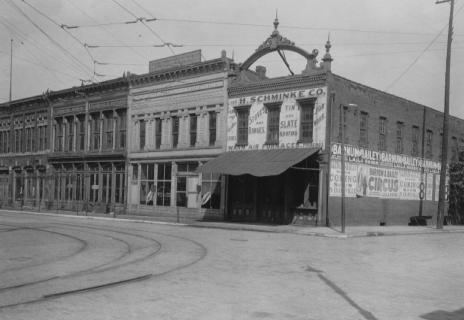 Vintage street view with buildings, tram tracks, and advertisements for circus and tin slate roofs.