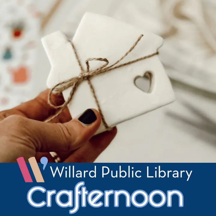 A person holds a white, heart-shaped craft item tied with twine, promoting a Crafternoon event at Willard Public Library.