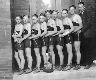 A vintage photo of a group of men in athletic attire with a trophy, suggesting a sports team celebration.