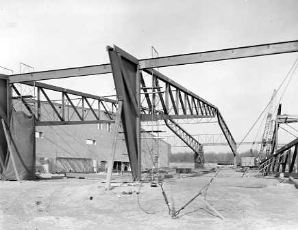 A construction site with steel girders being erected, forming the skeleton of a building structure.