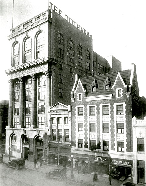 Vintage street scene with historic buildings and an old car.