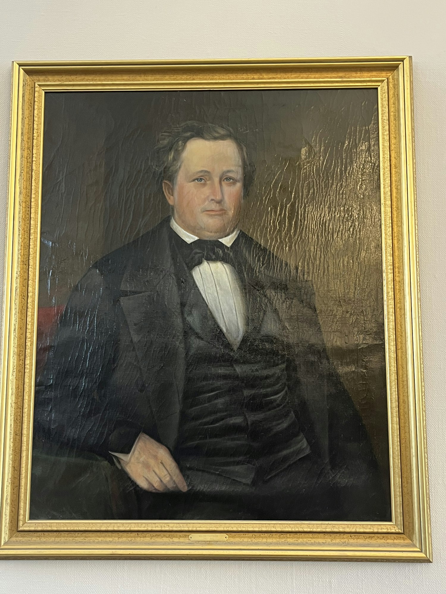 A framed portrait of a man in formal attire.