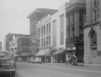 Vintage street view with old cars and buildings.
