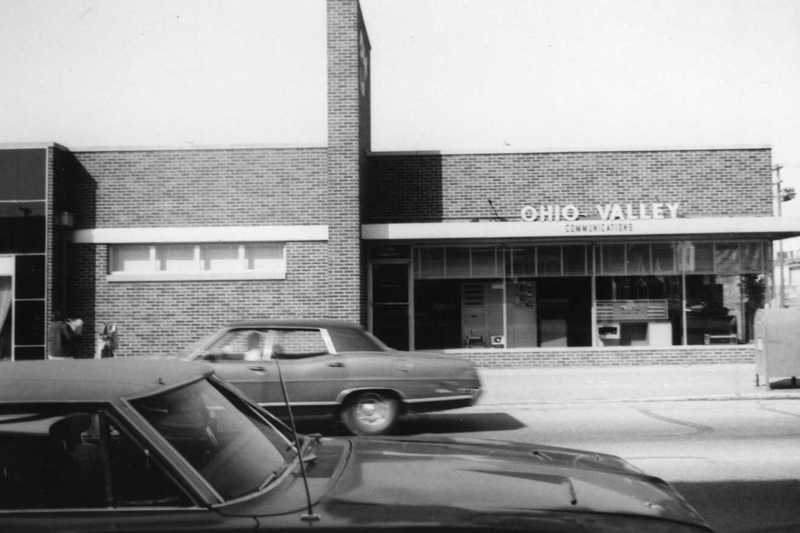 Vintage photo of a brick building with "OHIO VALLEY" sign, parked cars in front.