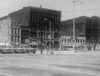 Vintage street view with old buildings and cars.