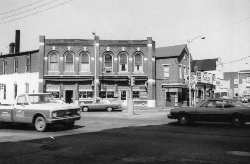 Vintage street scene with old buildings and cars.