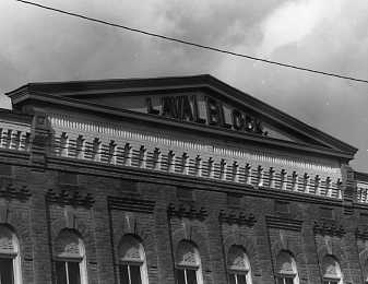 Black-and-white photo of a building with "LAW LIB." sign, classical architecture, decorative cornice, and arched windows.