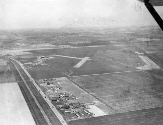 Aerial view of an airfield with runways and some buildings.