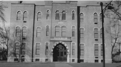 Historic building with arched entrance and symmetric windows.