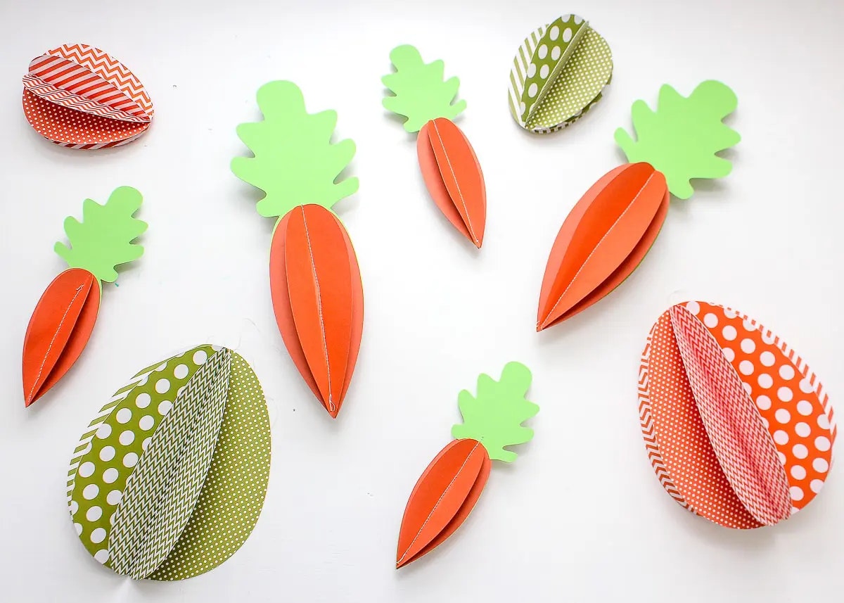 Colorful paper cutouts resembling carrots on a white background.