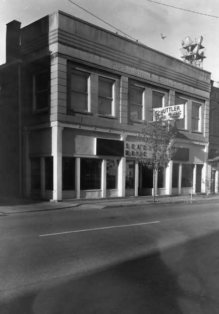 Black and white photo of a vintage building with a music store sign.