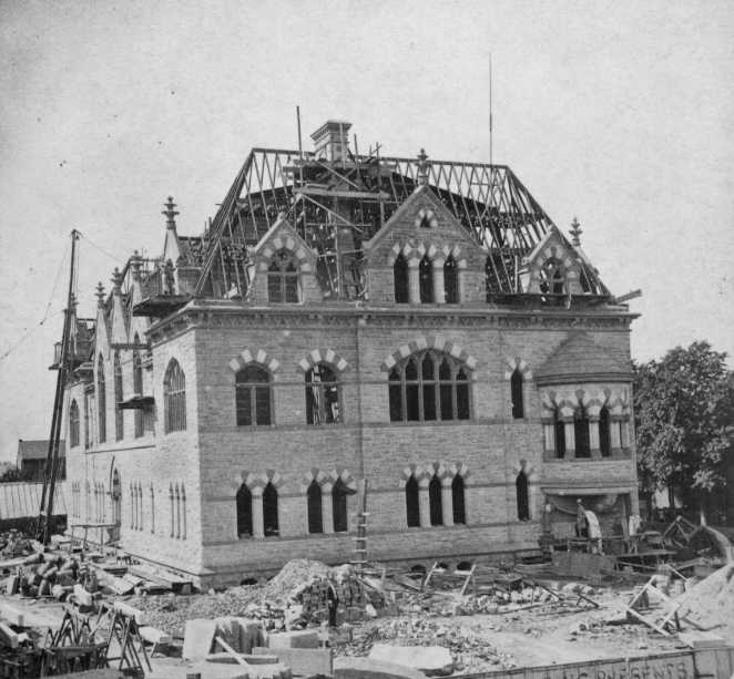Historic building under construction with scaffolding, debris, and a crane.
