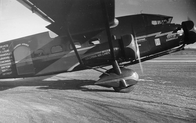 Vintage biplane with "Columbia Air Lines" markings on a textured surface.