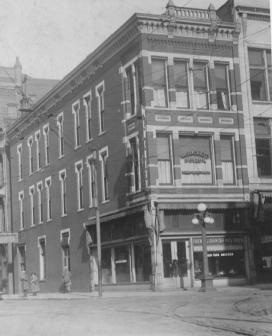 Historic street corner with vintage buildings and a person walking.