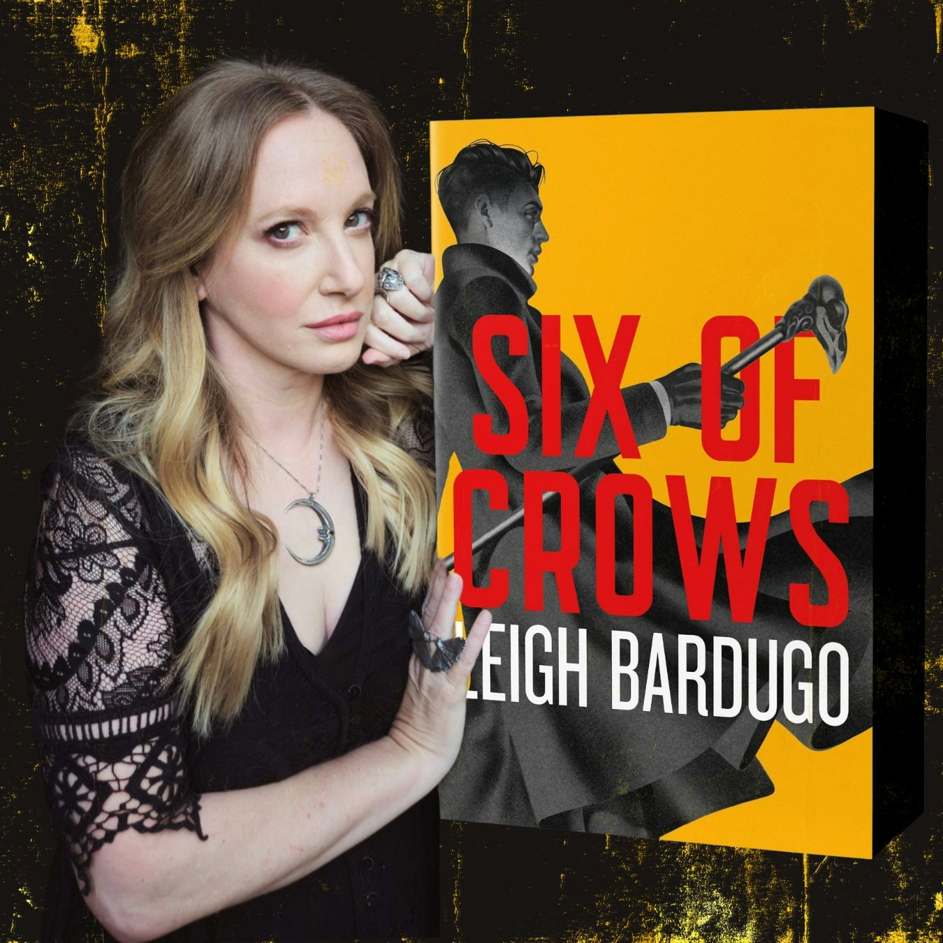 A person poses next to the book "Six of Crows" by Leigh Bardugo, featuring a yellow and black cover with red text.