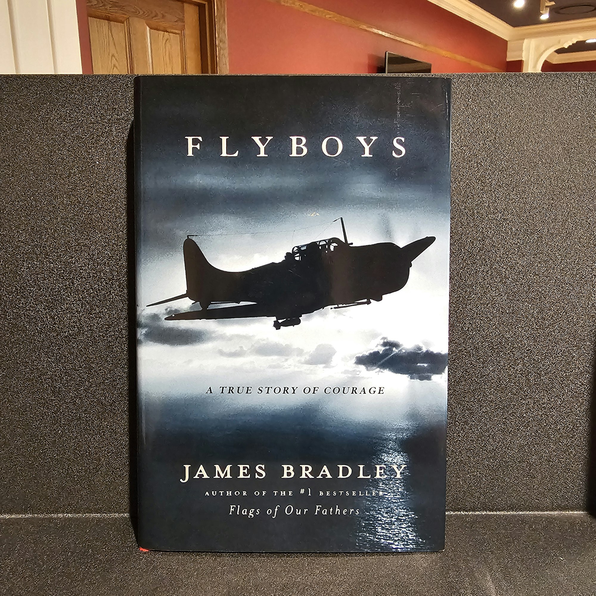 A book titled "Flyboys" by James Bradley, with an aircraft silhouette on the cover.