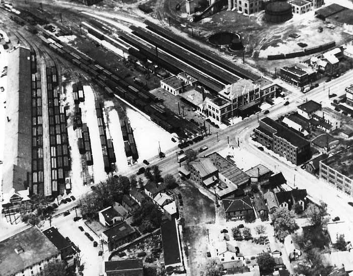 Aerial view of a railway yard with tracks, buildings, and some roads.