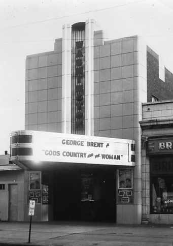 Vintage photo of an Art Deco-style cinema with a marquee showing "George Brent" and "GOD'S COUNTRY AND THE WOMAN".
