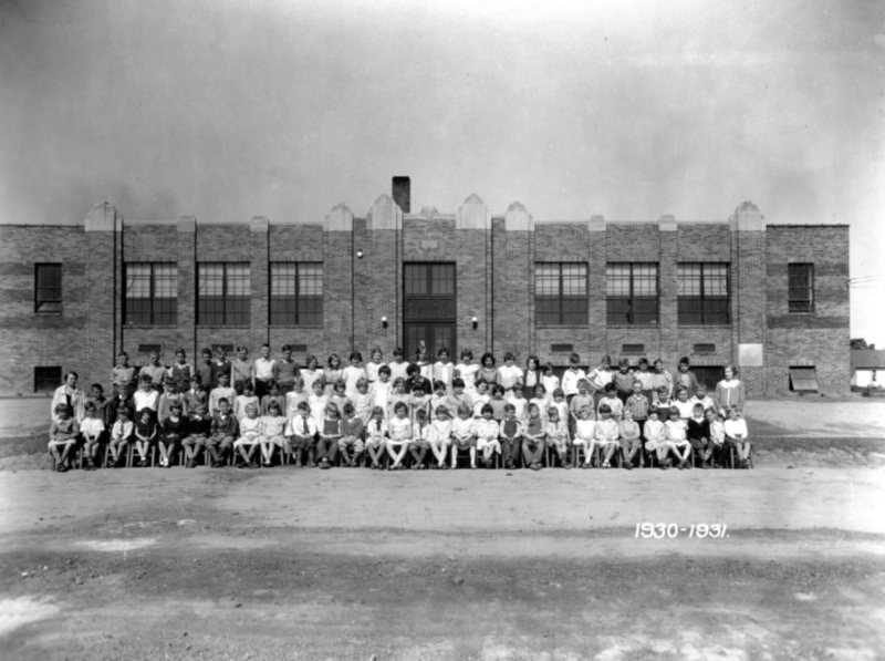 A black and white photo of a large group in front of a building, dated 1930-1931.