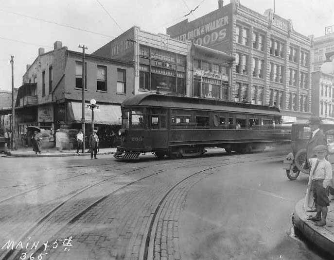 Historic street with a tram, pedestrians, and old buildings. Vintage urban scene.