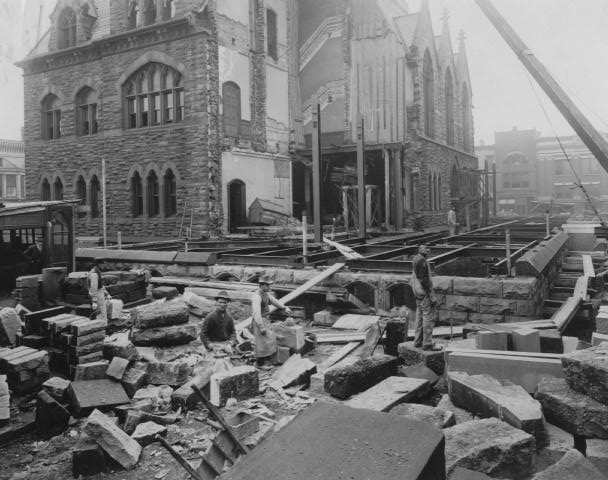 Historic building rubble with damaged facade and construction beams, aftermath of an unknown event.